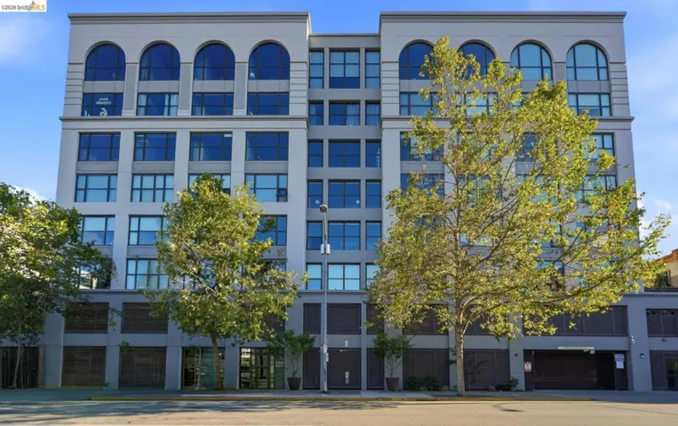 Modern multi-story building featuring a light gray facade