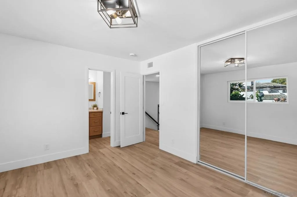 Spacious bedrooms in the main house.  This one can be considered a second primary bedroom.  It adjoins the second full bath upstairs.  Mirrored closet doors and brand new windows.