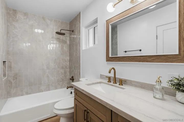 Second full bathroom upstairs serves the secondary bedrooms.  Tub in shower, brand new tile and brand new vanity, counters and fixtures.