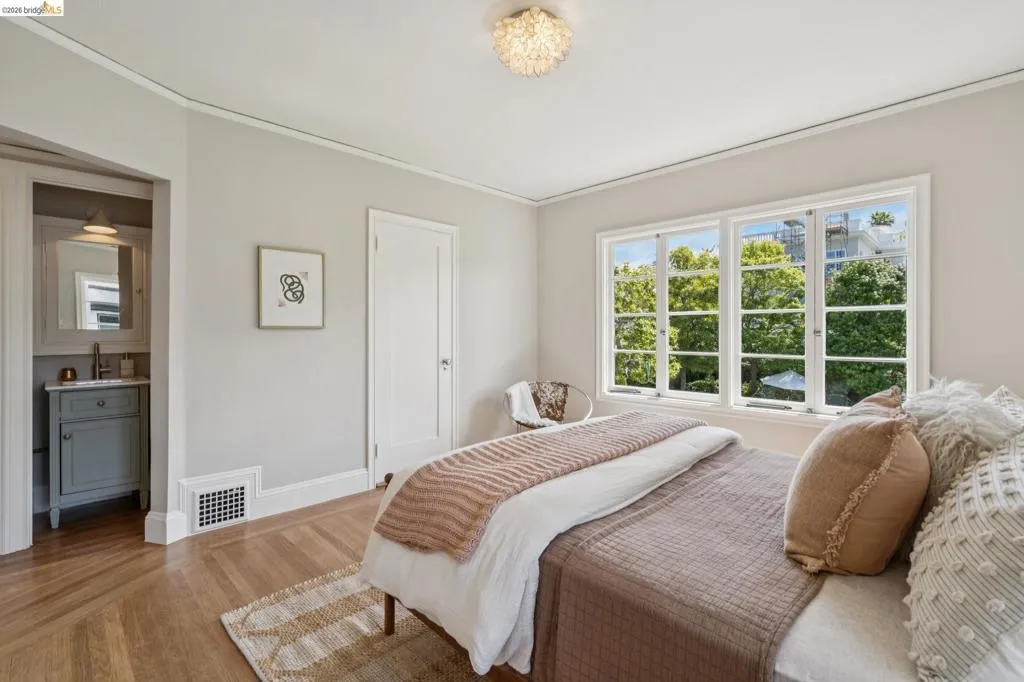 Bedroom with en-suite split bath, featuring light-colored walls and wood-finish flooring. Cedar lined closet.