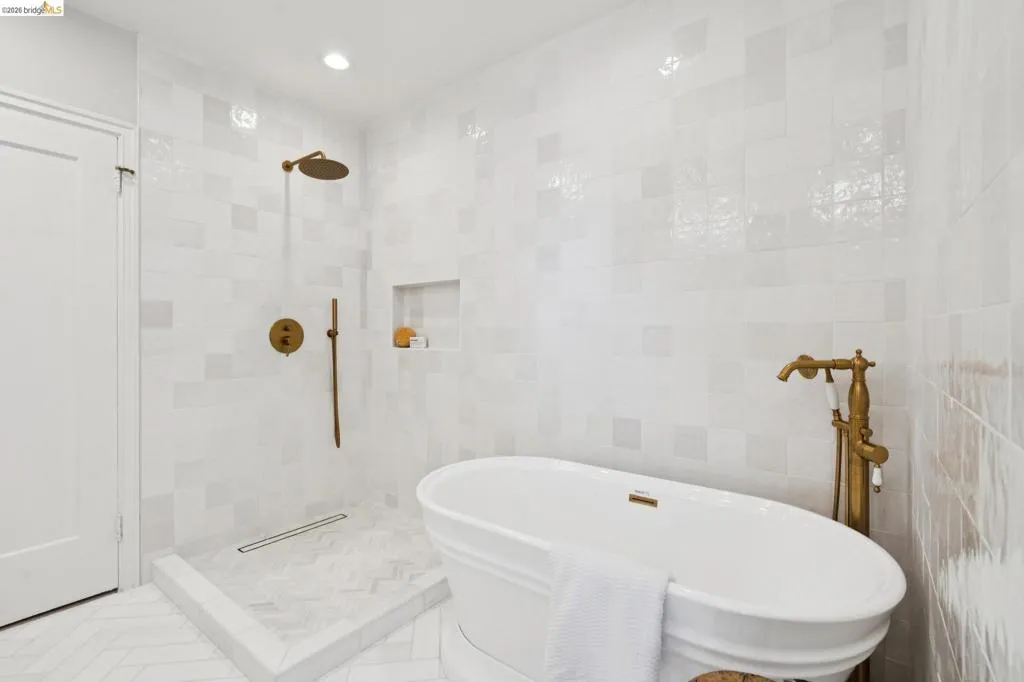 Freestanding soaking tub with a floor-mounted brass faucet