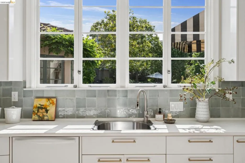 Kitchen workstation featuring an undermount stainless steel sink, a gooseneck faucet, and a light-colored countertop