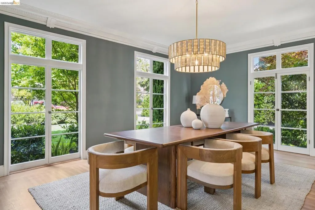 French doors with multiple panes, crown molding, wood-finish flooring, and a tiered chandelier
