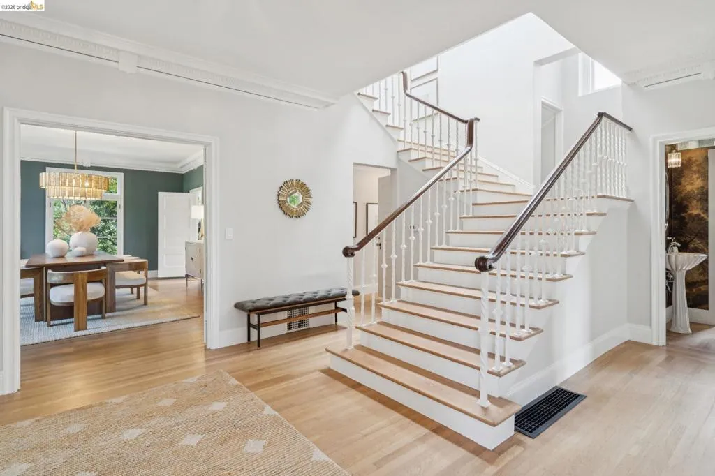 Grand foyer featuring a bifurcated staircase with wood-finish treads and white balusters