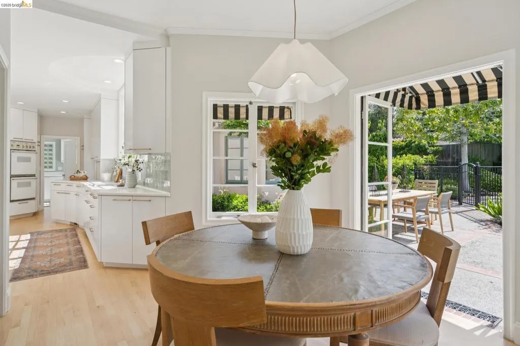 Dining area with light wood-finish flooring, a built-in kitchen, and an exterior patio
