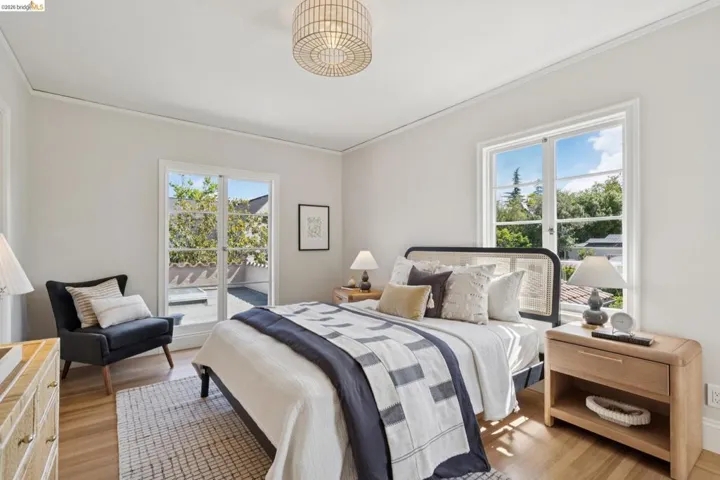 Bedroom featuring wood-finish flooring, a contemporary ceiling light fixture, and crown molding