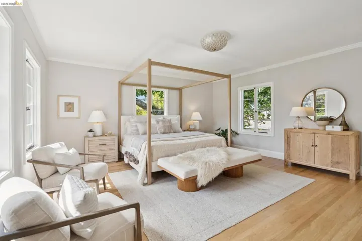 Spacious room featuring wood-finish flooring, multiple casement windows, and a decorative ceiling light fixture