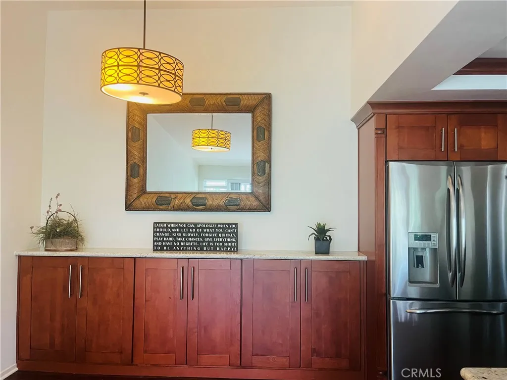 Designer kitchen includes recessed lighting framed by cabinet-matched crown molding.