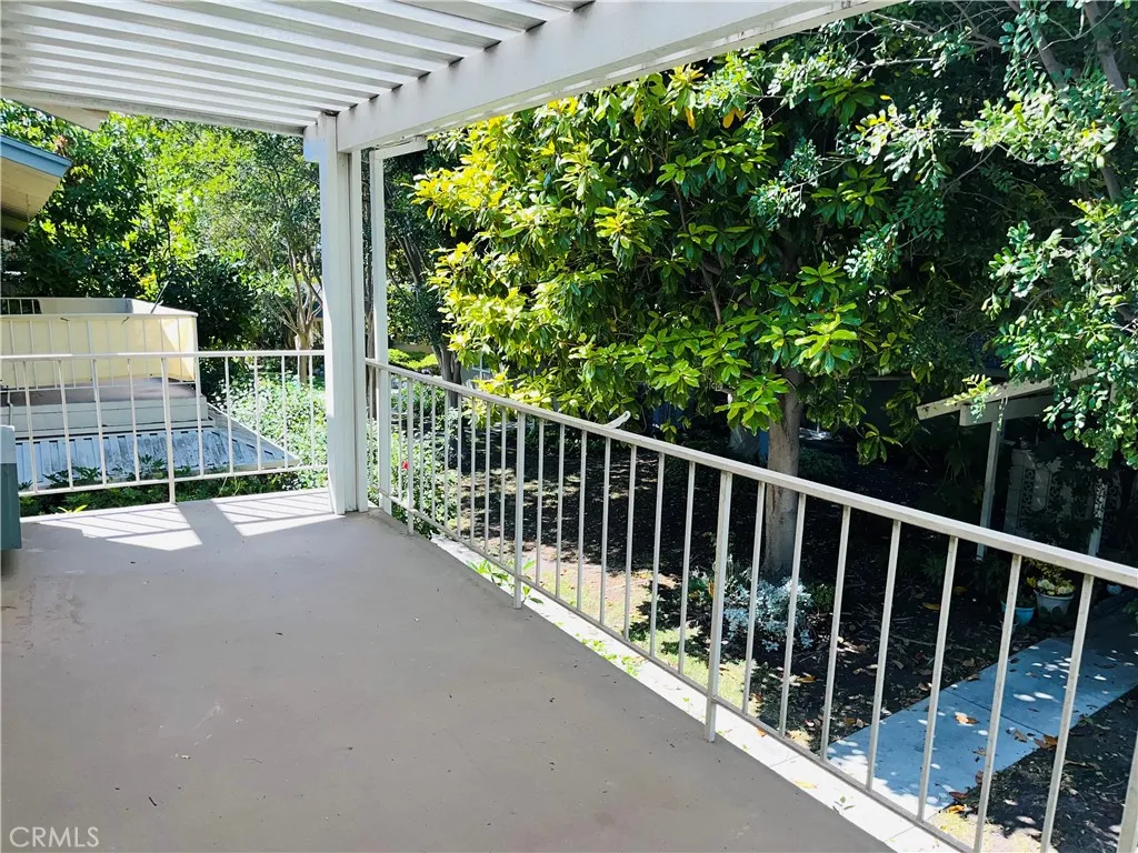 Large balcony capped by a designer patio cover offers outdoor living (photos from prior listing; fence lLiving room, with upgraded wood-like flooring, has access to a large balcony open to the tree tops and numerous walking trails