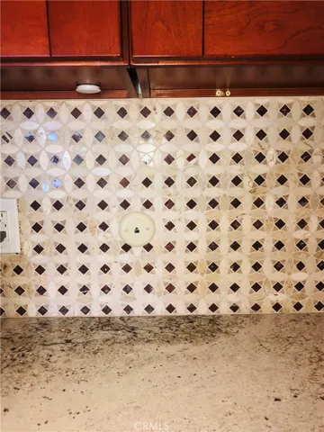 Closeup of kitchen granite counter and custom stone design on backsplash.