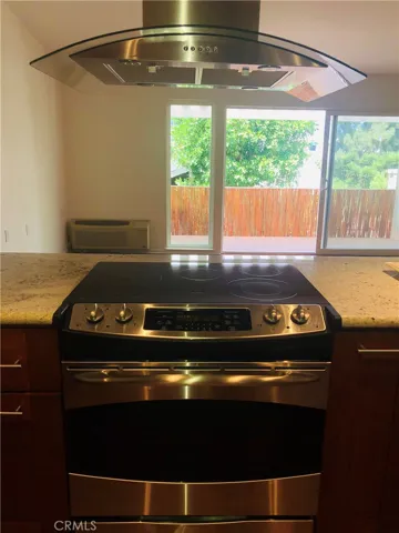 Contemporary range and hood with glass accents looks out to patio (some prior photos from listing used, fence lattice since removed)
