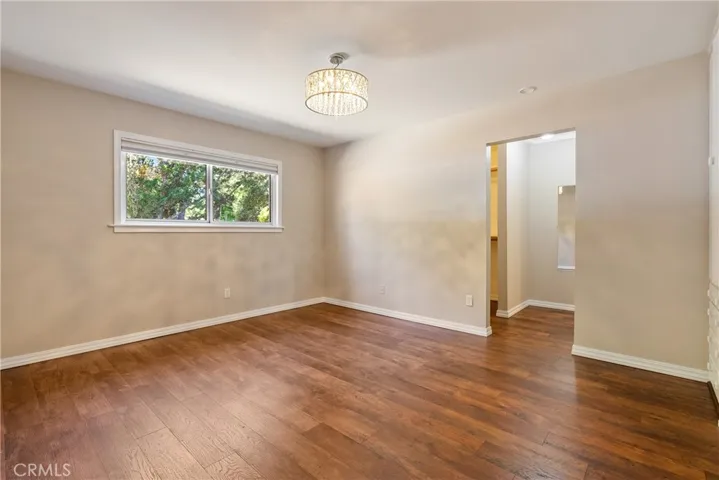 Bedroom 3 features engineered hardwood floors and a crystal chandelier.