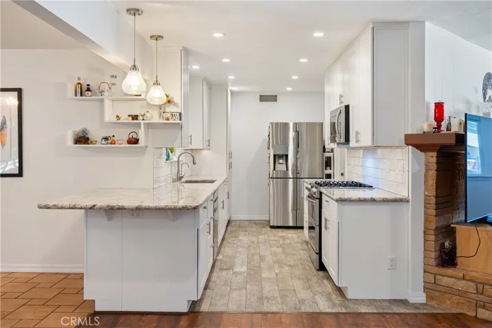 The kitchen was tastefully remodeled with shaker style cabinets, granite countertops and recessed lighting.