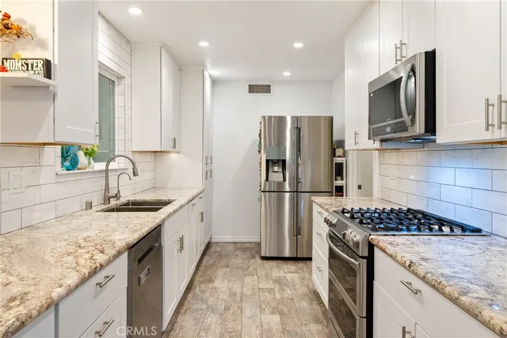 The kitchen provides ample cabinetry for storage and abundant countertop space for preparing or serving meals. The refrigerator stays!