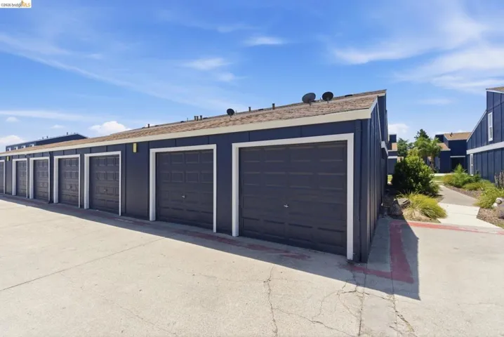 Building exterior with dark blue siding, white trim, and multiple garage doors
