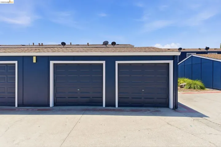 Multiple garage doors featuring dark paneling and white trim