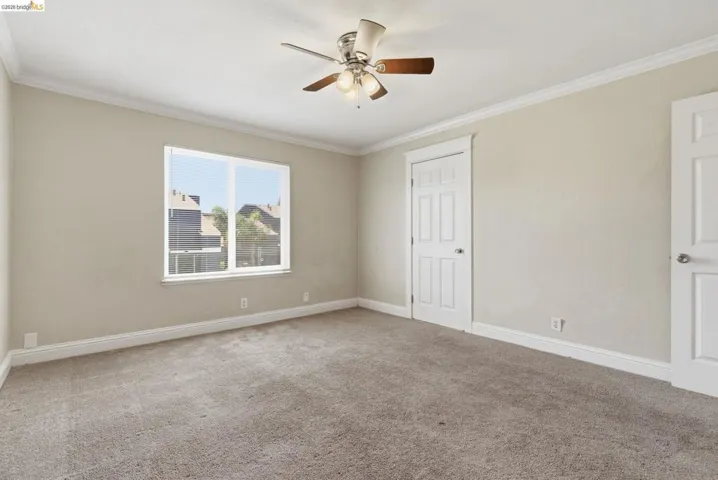 Neutral-toned room with plush carpeting and a multi-pane window