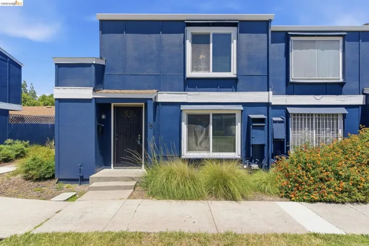 Two-story townhouse exterior with a bold blue facade and white trim