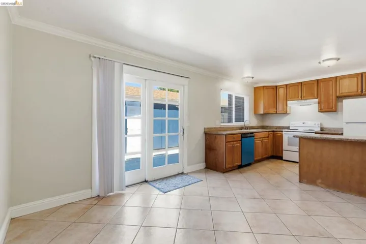 Kitchen area featuring natural wood cabinetry, stone-finish countertops, and tile flooring