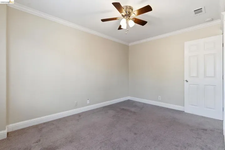 Neutral wall tones with crown molding and baseboards