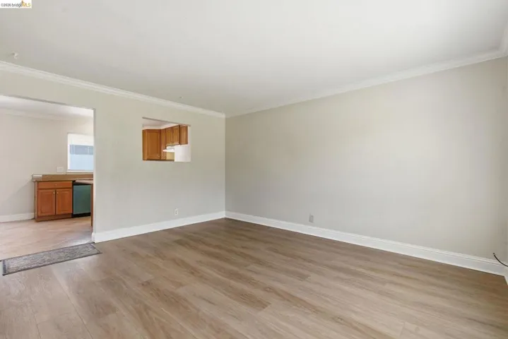 Living area featuring wood-finish flooring and crown molding