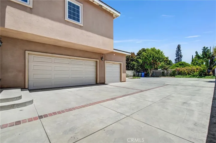 Large concrete rear yard with attached 3-car garage.