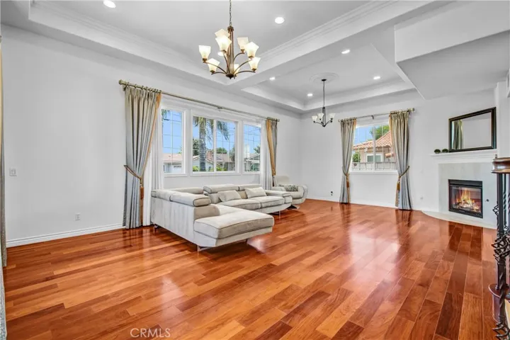Ground living room featuring soaring ceilings, abundant natural light and rich-toned flooring.