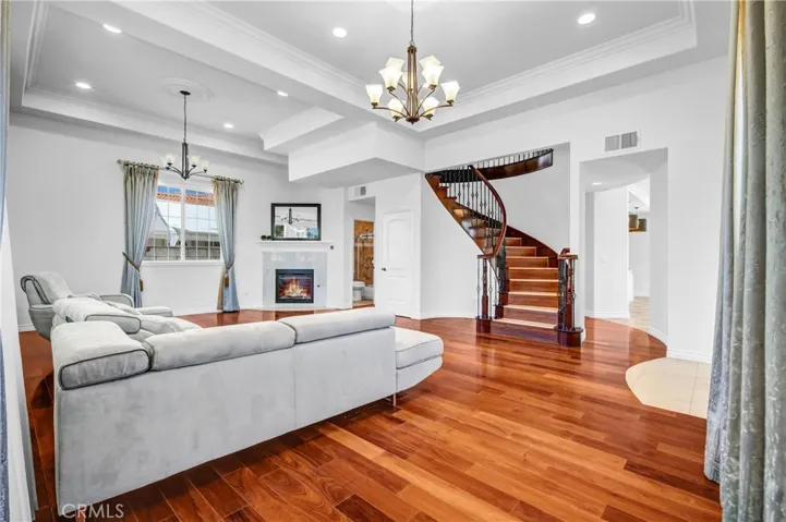 Living room with fireplace and elegant staircase.