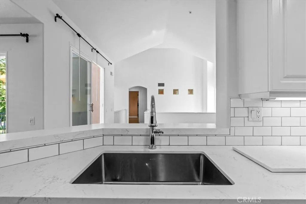 View from kitchen sink to living area, showing soaring vaulted ceiling