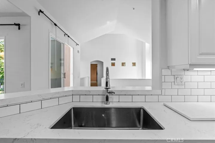 View from kitchen sink to living area, showing soaring vaulted ceiling