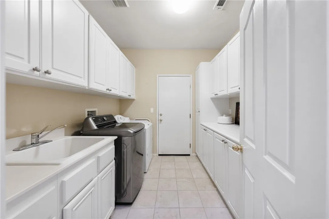 Large laundry room with added cabinets and deep sink.