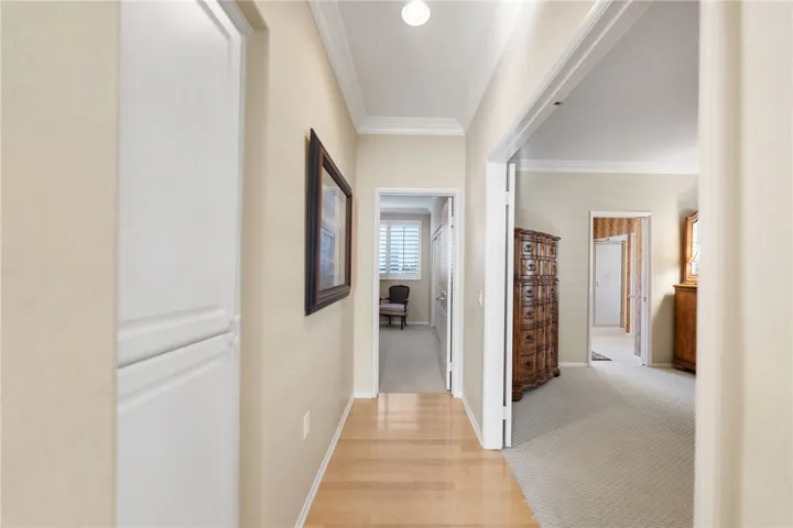 Hallway to primary bedroom and secondary bedrooms being used as an office
