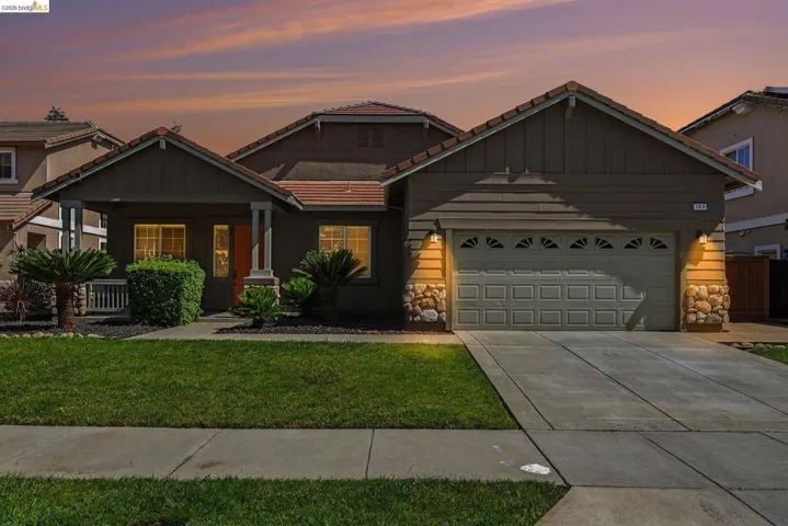 Single-story residence featuring a tile roof, stucco and stone-veneer facade, and an attached two-car garage