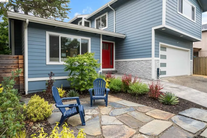 Contemporary exterior featuring blue horizontal siding and a red entry door