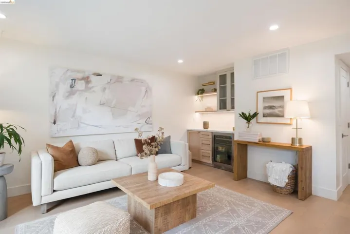 Recreation room featuring light wood-finish flooring, recessed lighting, and a built-in wet bar with cabinetry and under-counter beverage refrigerators