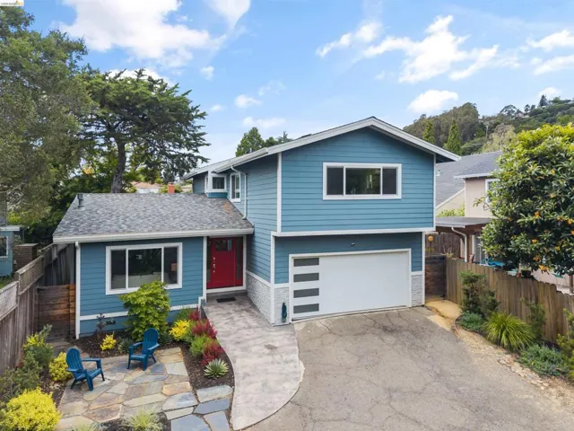 Blue siding exterior with white trim, a red front door, and an attached two-car garage