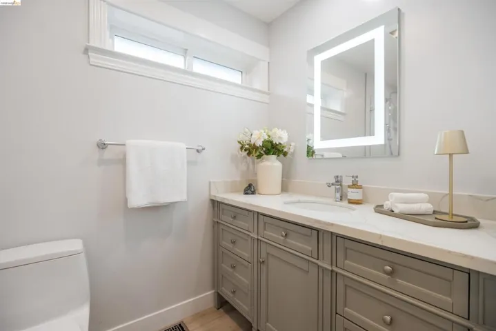 Bathroom featuring a large vanity with stone-finish countertop, undermount sink, and integrated cabinetry