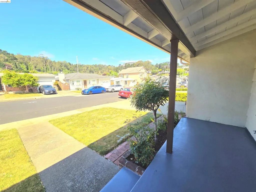 Covered front porch with painted concrete flooring and exposed wooden beams