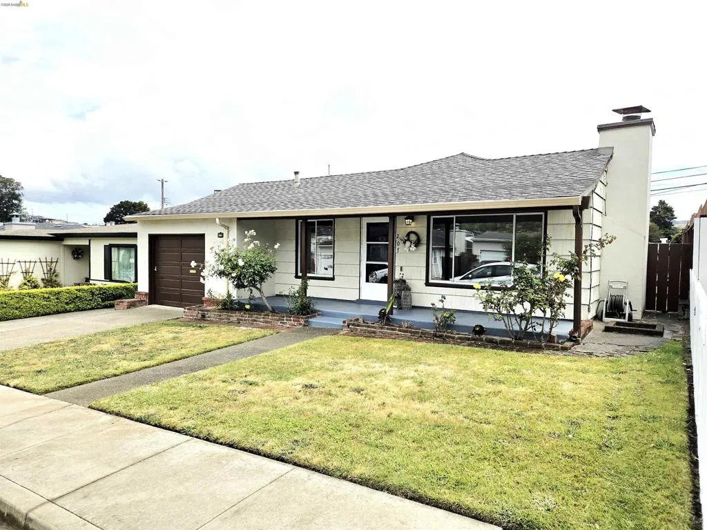 Single-story residence featuring a shingled roof, a prominent front window, and a light-colored exterior siding