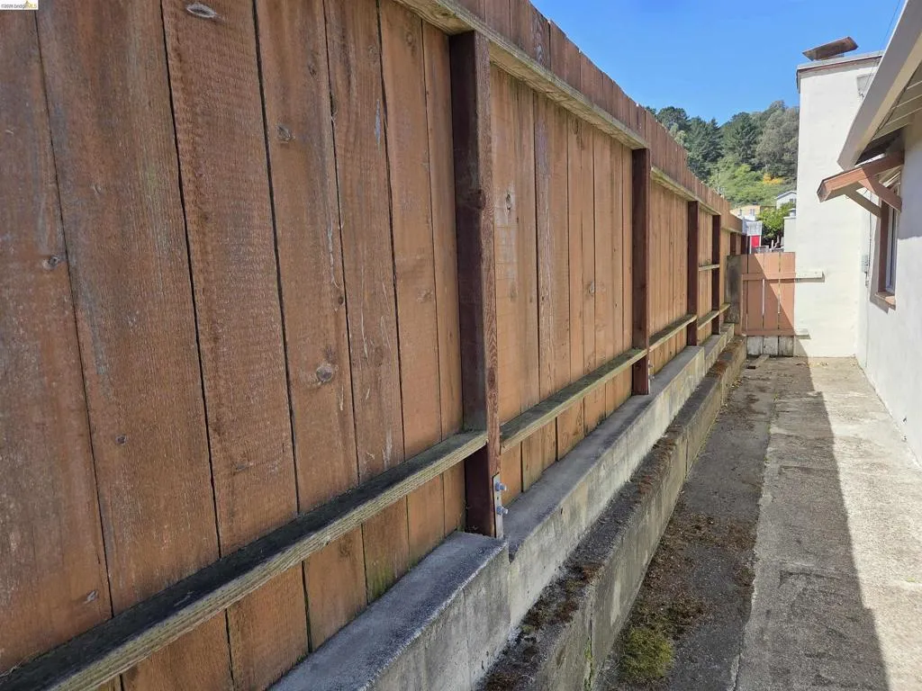 Wood panel fencing with a concrete retaining wall
