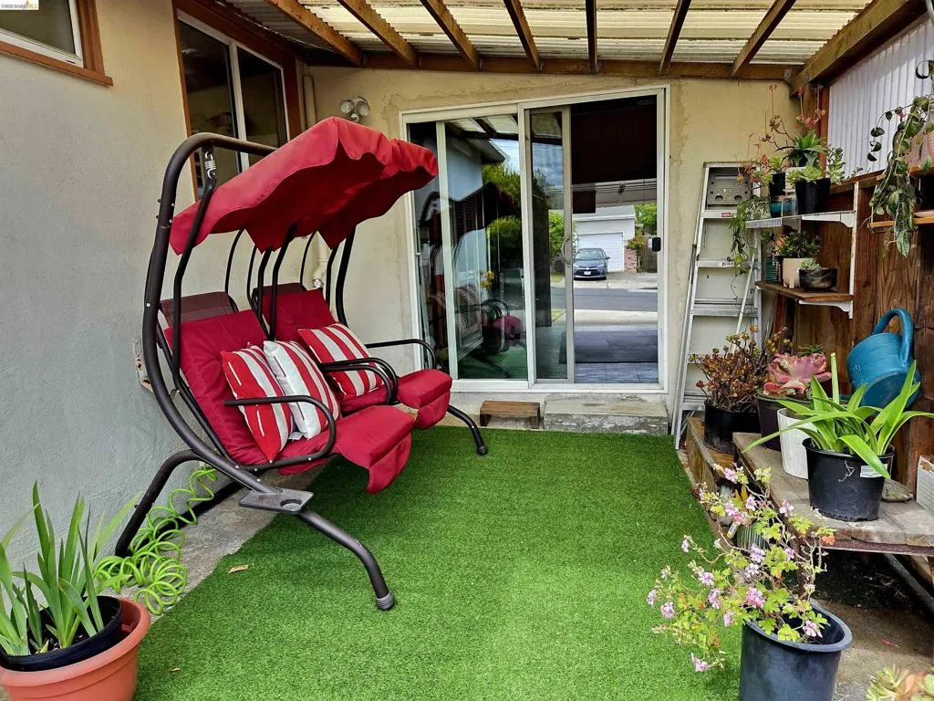 Covered patio area featuring a sliding glass door and artificial turf flooring