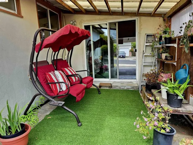 Covered patio area featuring a sliding glass door and artificial turf flooring