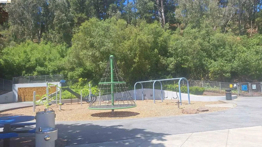 Recreational playground area featuring varied play structures, swing sets, and a climbing apparatus