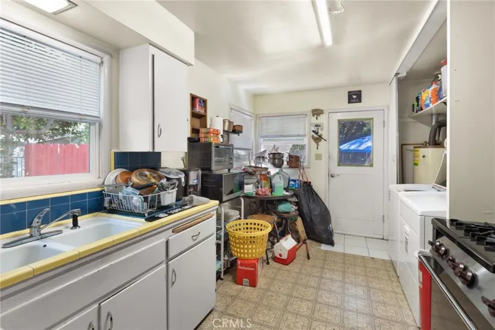 House - view of kitchen, tile counter tops, inside laundry hook ups.  Gas range, washer and dryer belong to tenants.