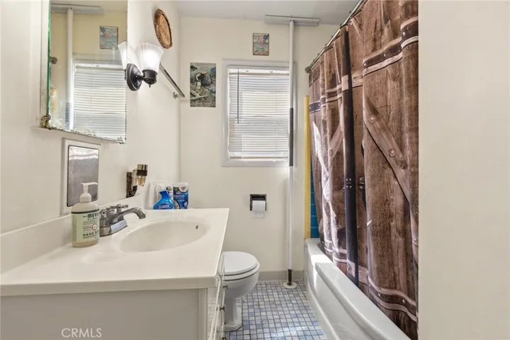 House - Bathroom with tile floors and tile around the bath tub shower area.