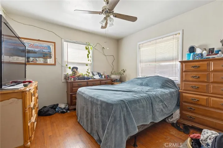 House - Primary bedroom with wood floors and ceiling fan.