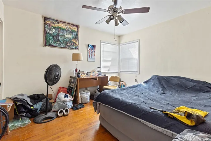 House - Bedroom 2 with wood floors and ceiling fan.