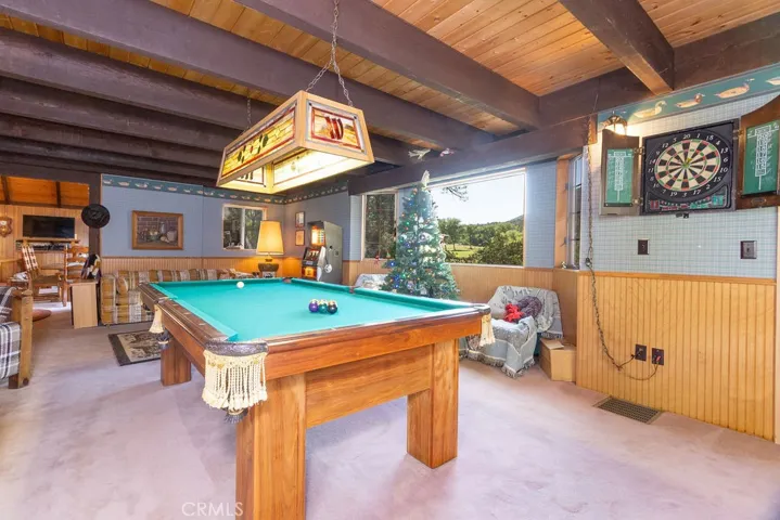Besides the pool table, there is a slot machine, dart board, bar and a a fireplace with seating area.