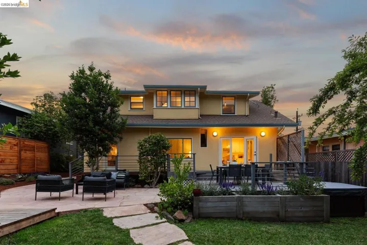Expansive backyard featuring a manicured lawn, a large flagstone patio, and a raised wooden deck
