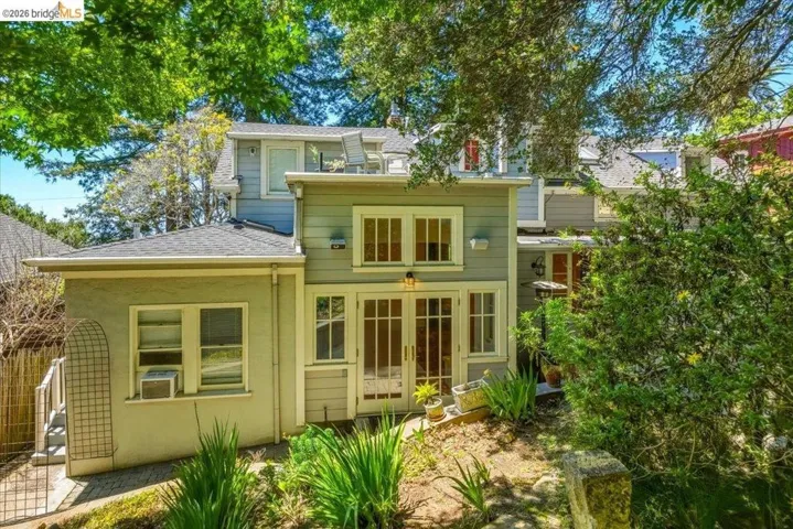 Multi-level exterior with dormer windows, French doors, and an outdoor staircase